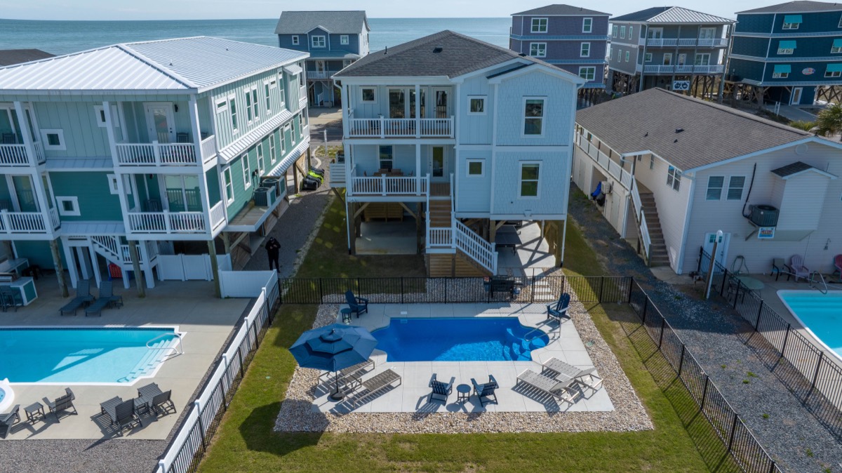 Aerial view of Palmers Place with the fenced pool and the ocean beyond