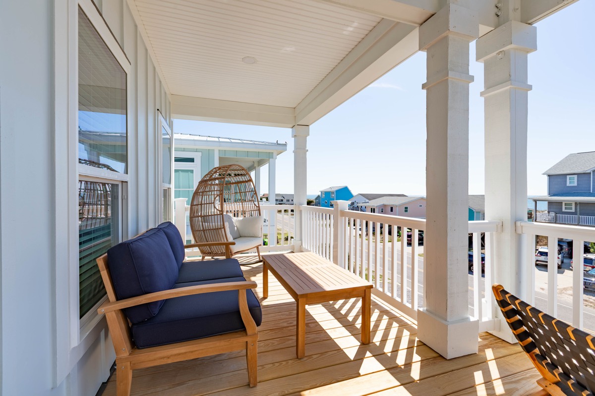 Covered porch with seating and a hanging egg chair