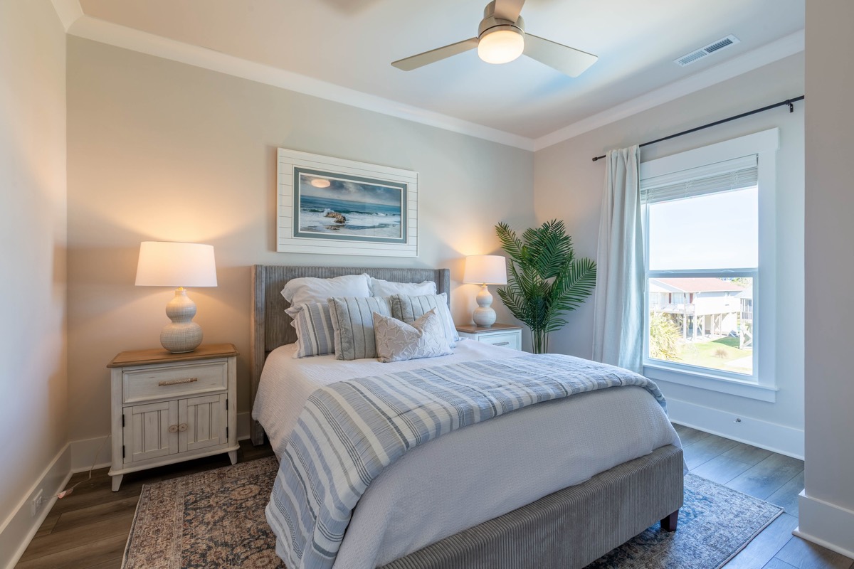 Bedroom with coastal art and a large window