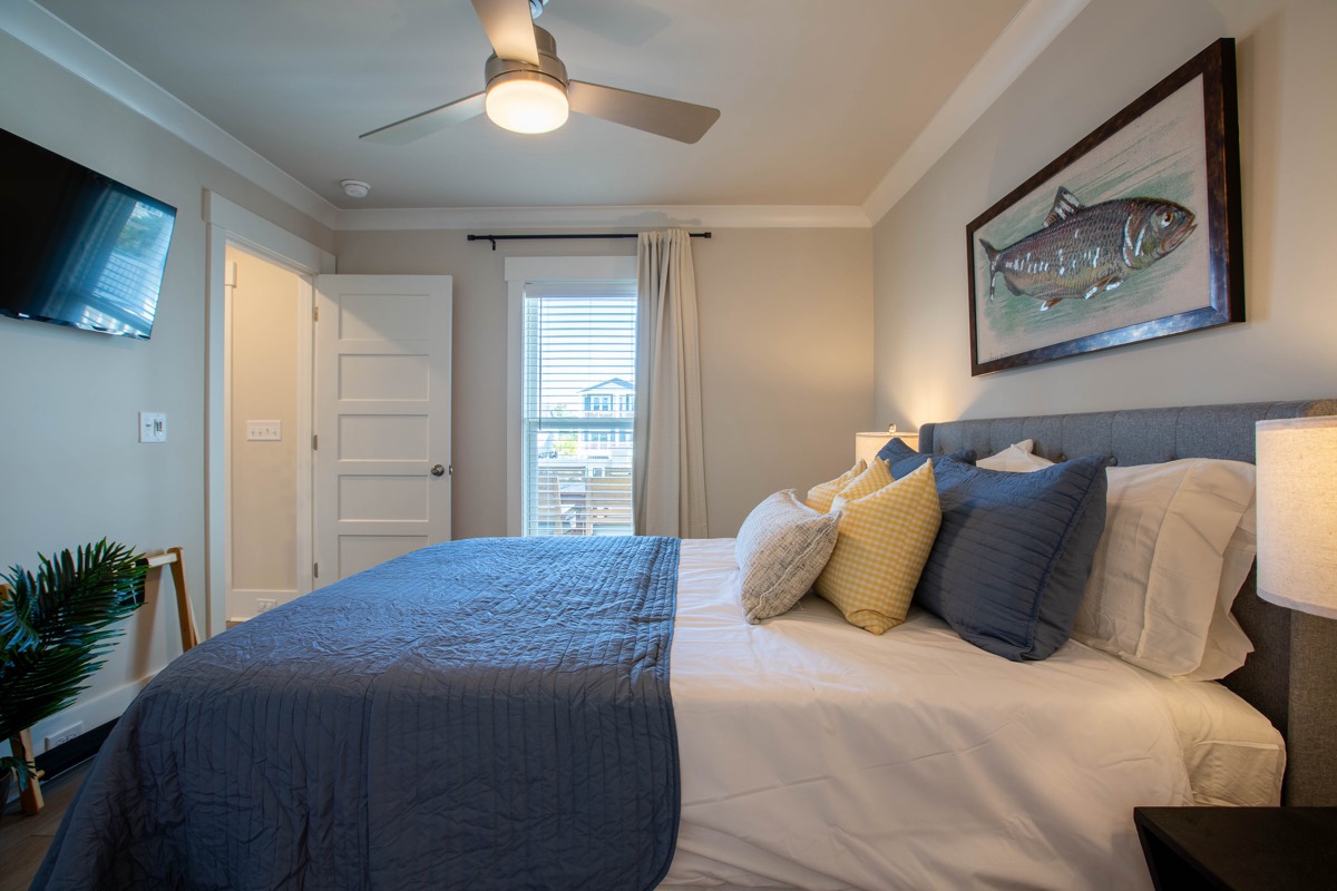 Bedroom with fish artwork and a wall-mounted TV