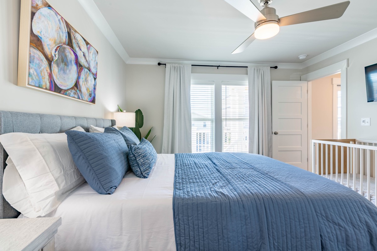 Bedroom with seashell artwork and a crib